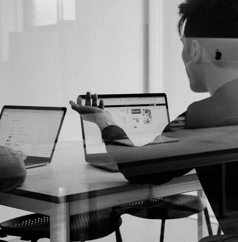 two people sitting on their laptop computers in s a business meeting